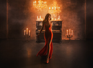 Dark Silhouette fantasy lady gothic beautiful woman blond hair in red dress walks in luxurious room black piano candles light burn. Evening dress slit on long leg fashion model sexy girl vampire queen