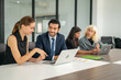 © Suriyo - Group of coworkers in formal wear sitting at table in conference room. Business meeting team in office