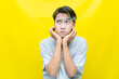 Thoughtful confused asian man thinking and wondering to choose something isolated over yellow background. indonesisan man feeling uncertain and unsure.	