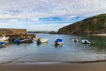 Pleasure Boats Berthed At Polkerris In Cornwall, A Delightful Sandy Cove With A Small Harbour, On A Summer Morning.