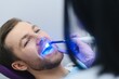 © Serhii - Closeup portrait patient in dental office - ultraviolet light equipment