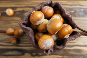 Hazelnuts in burlap on a wooden background. a slide or stack of hazelnuts. Selective focus