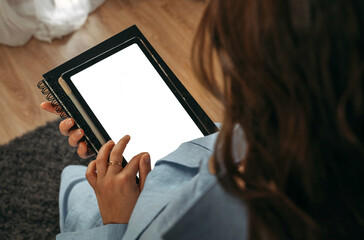 A woman holds a tablet in her hands, on the screen of which there is free space. Mockup.