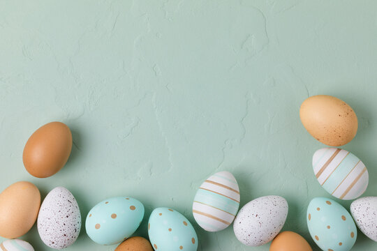 Fototapete - Easter frame of pastel colored eggs on light green background. Flay lay, top view with copy space.