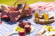 © Wavebreak Media - Close up of blanket with fresh fruit, cheese, bread in basket and drinks in garden