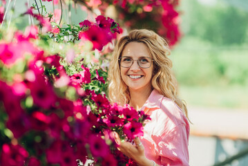 Wall Mural - Young woman working in a greenhouse and taking care of the plants