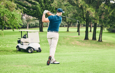 Golf, stroke and grass with a sports man swinging a club on a field or course for recreation and fun. Golfing, hobby and training with a male golfer playing a game on a green during summer