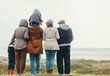 © Allistair/peopleimages.com - Family hiking outdoor, generations at beach together with nature view and back, spending quality time in winter. Grandparents, parents and children, love and care with people at the coast