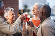 © Wesley J/peopleimages.com - Friends, senior people with wine and retirement party, cheers and glasses with happiness, celebration and fun outdoor. Mature, men and women with diversity, alcohol drink and celebrate with team