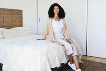 Black Woman Relax, Bedroom And Home Interior Of A Young Female Sitting On A Bed Feeling Relax. House, Morning And Person Calm On A Blanket And Duvet On A Mattress Getting Ready For A Nap And Day Rest