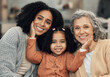 © Allistair/peopleimages.com - Family, love and portrait by girl with mother and grandmother on a sofa, happy and smile in their home. Bond, relax and face of senior woman with adult daughter and grandchild on couch on the weekend