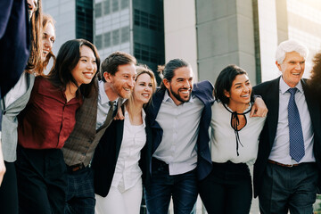 Happy business group of people having fun outdoors with office buildings in background - Bank company coworkers concept