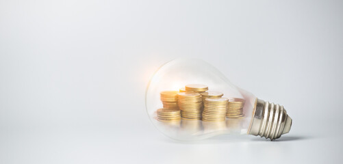 Stack of coins inside a light bulb for saving money concept, Creative ideas of business planning, success in the future.
