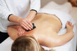 © Kalim - Woman having a gua sha massage in salon