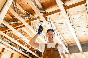 An Electrician Male Working on basement bulb