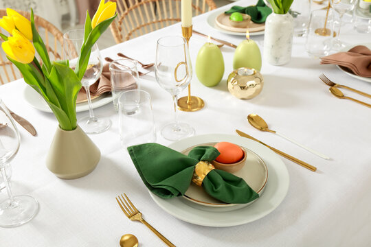 Wall Mural - Festive Easter table setting with painted eggs, burning candles and yellow tulips