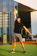 © djile - Handsome young man working out with kettlebell  in an outdoor gym