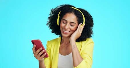 Wall Mural - Phone, music headphones and woman dancing in studio isolated on a blue background. Technology, cellphone and happy female dance while streaming, listening and enjoying podcast, radio or audio sound.