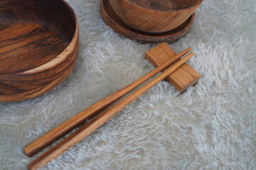 Wooden Chopstick and empty wooden bowl on a gray table, top view