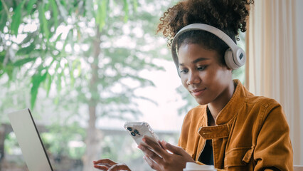 Wall Mural - Using headphones. Young african american university foreign exchange students study online on laptop pc english language class by international specialists with master at cafe.