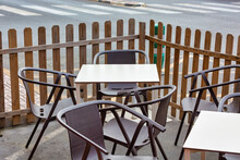 Brown Chairs With White Tables At A Street Cafe