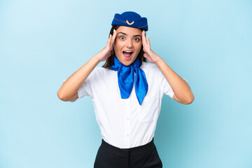 Wall Mural - Airplane stewardess caucasian woman isolated on blue background with surprise expression