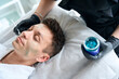 © Svitlana - Lady apply revitalizing mask for face on man skin