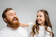 © LIGHTFIELD STUDIOS - Excited kid and father in white t-shirts laughing isolated on grey.
