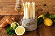 Fresh white asparagus with ingredients for a menu on rustic wood. Kitchen scene for a seasonal and healthy gastronomy concept. Close-up.