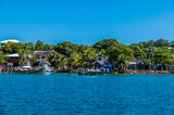 Fototapeta  - A view of boats and buildings at West Bay on Roatan Island on a sunny day