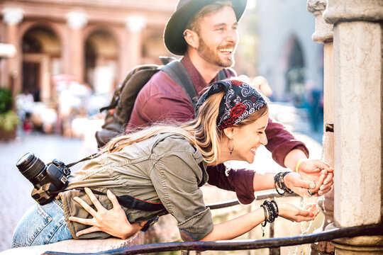young hipster couple in love having genuine fun wandering at city center - wanderlust life style and