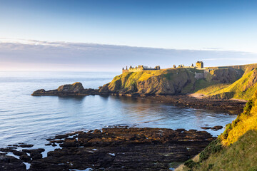 Wall Mural - Dunnottar Castle bathed in gorgeous morning sun, taken from the cliffs above Castle Haven near Stonehaven in Aberdeenshire.