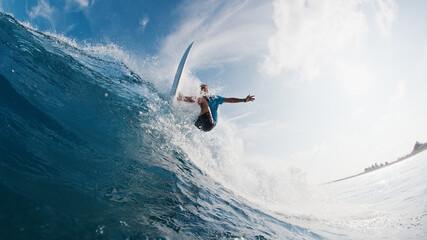 Poster - Pro surfer rides the wave. Young man surfs the ocean wave in the Maldives and aggressively turns on the lip. Splitted above and underwater view