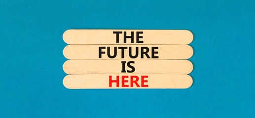 Wall Mural - The future is here symbol. Concept words The future is here on wooden stick. Beautiful blue table blue background. Motivational business the future is here concept. Copy space.