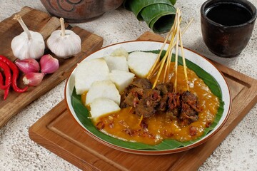 Sate Padang. Spicy beef satay from Padang, West Sumatra. Served with spicy curry sauce and rice cake