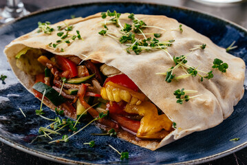 turkish pita with meat, vegetables and sauce on a plate