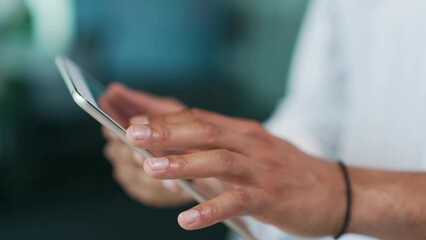 Close up The hand of a doctor in a white coat is holding a tablet in a clinic at the workplace. A therapist at work uses a pad, moving a finger on the screen, searching for information on the Internet