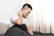 © Anciens - Asian man is suffering stiff neck in the bed.