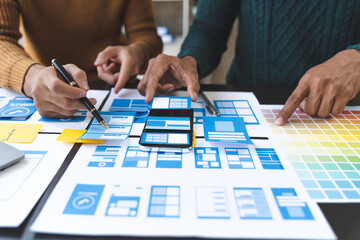 A group of Asian UI developers, designers, and data researchers are brainstorming their projects with laptops, smartphones, and digital tablets. Creative Digital Development Agency.