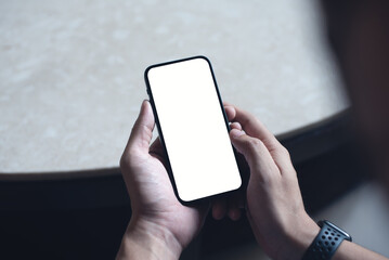 Wall Mural - Mockup image of mobile phone for advertising. Mock up image of man hand holding and using smartphone with blank screen for mobile app design or text advertisement