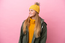 Young Blonde Woman Wearing Winter Jacket Isolated On Pink Background Looking Side