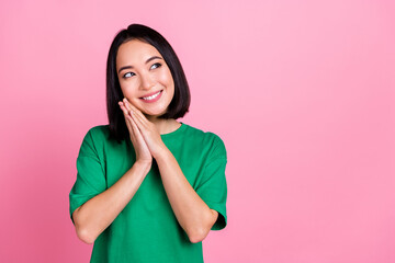 Poster - Photo of cute gorgeous girl with bob hairdo dressed green t-shirt palms on cheekbone look empty space isolated on pink color background