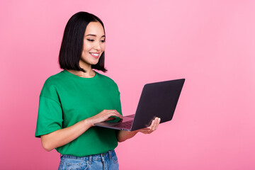 Poster - Portrait of cheerful cute woman straight hairstyle wear oversize t-shirt look at laptop distance meeting isolated on pink color background