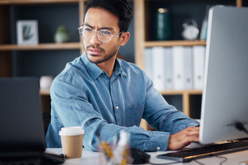 Serious, business man working on computer, laptop and software development, digital research and information technology. Coding developer or asian person typing on desktop for multimedia management