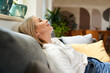 © baranq - Smiling woman resting on a sofa relaxed with eyes closed