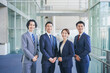 © HML - オフィスの廊下に並んで立つビジネスマンの男女