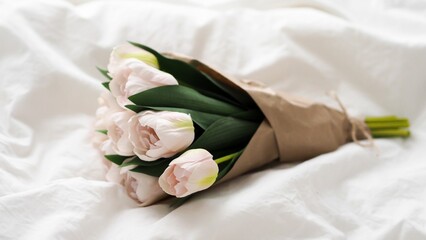 Sticker - Small pretty bouquet of white tulips on the sheets of a bed