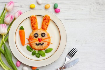 Wall Mural - Mini Easter bunny pizza on plate with white wood background.Art food idea for kids Easter's party.Top view.Copy space