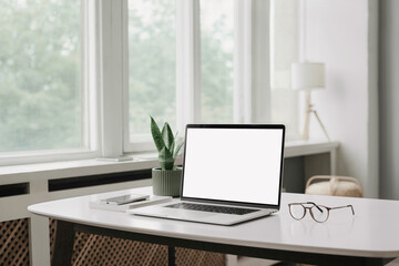 Laptop computer with empty blank mockup screen over white modern living room design. Home office, workplace, working or studying from home, distance learning, business concept