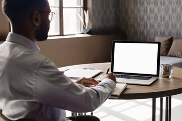young man using laptop computer with blank empty mockup screen. business man working at home. freela